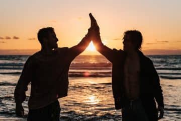 Deux amis qui font un hi five sur la plage